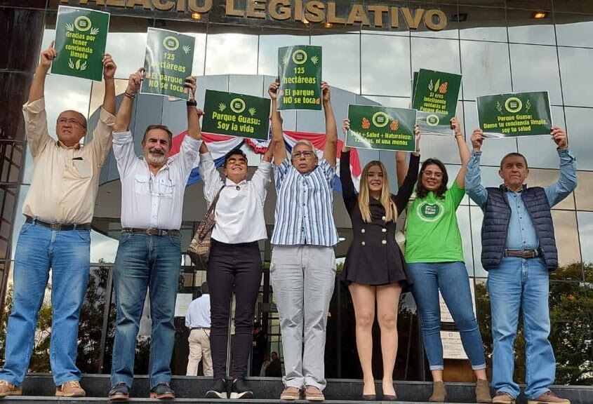 Integrantes de la agrupación levantan carteles frente al Palacio Legislativo